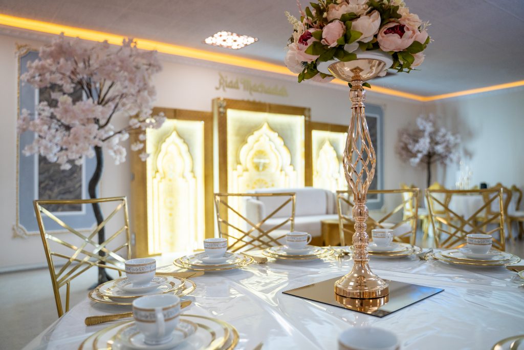 Festlich gedeckter Hochzeitssaal Riad Mashallah in Karben mit goldener Tischdekoration und Blumenschmuck