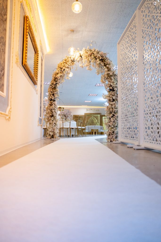 Blumengeschmückter Hochzeitseingang im Riad Mashallah Karben mit weißem Teppich und festlicher Beleuchtung