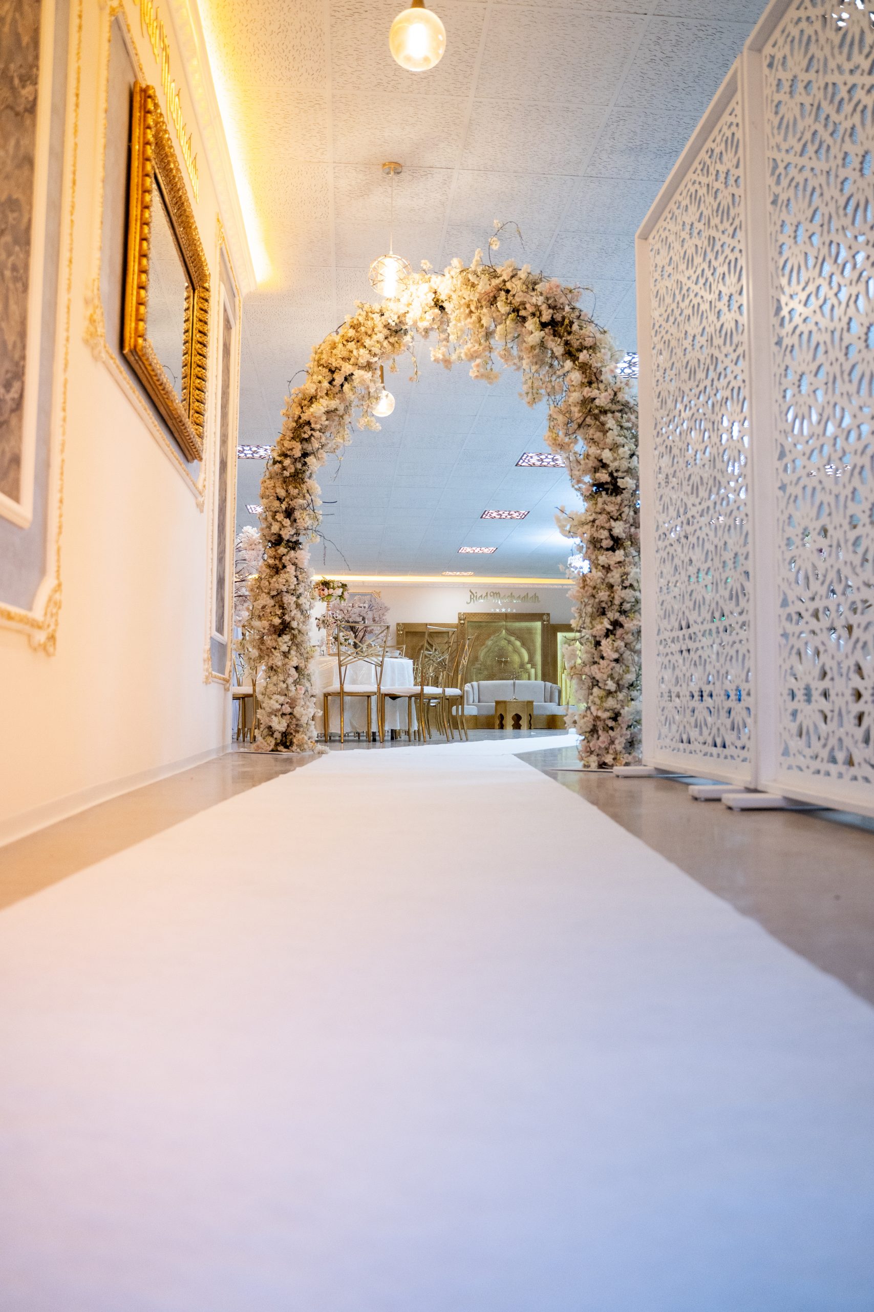 Blumengeschmückter Hochzeitseingang im Riad Mashallah Karben mit weißem Teppich und festlicher Beleuchtung