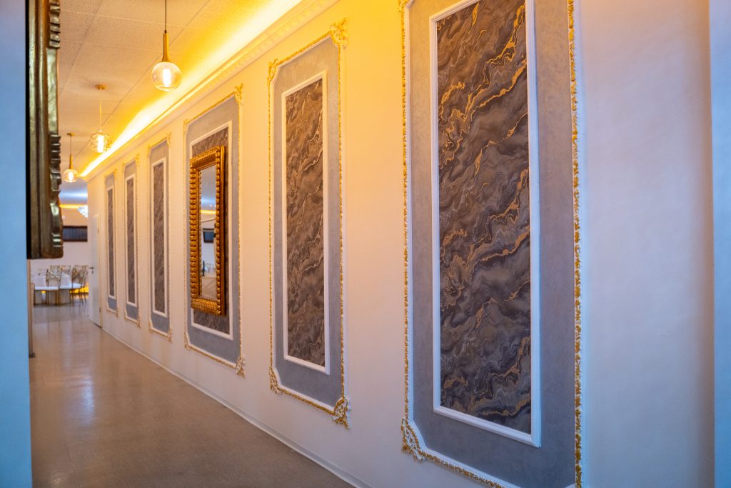 Eleganter Flur im Riad Mashallah Karben mit goldenen Wandverzierungen und stilvoller Beleuchtung