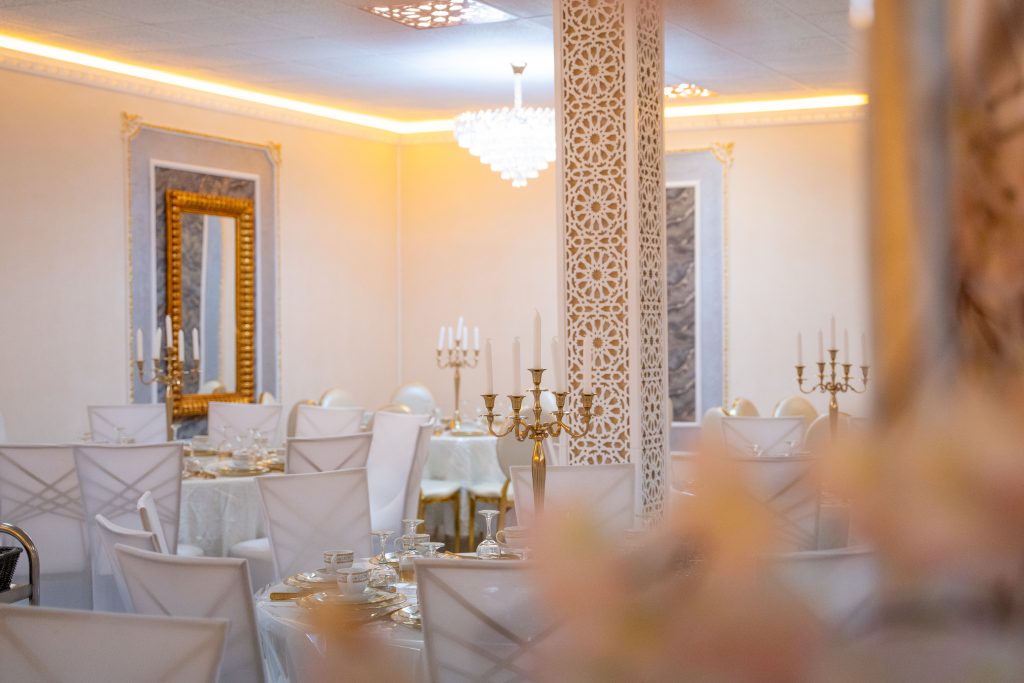 Eleganter Bankettsaal im Riad Mashallah Karben mit goldenen Kerzenständern und luxuriösen Wandverzierungen